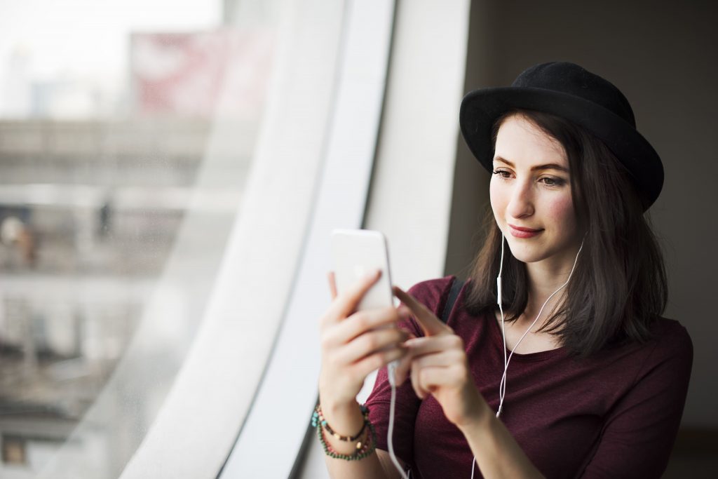 avanco-da-tecnologia-jovem-mexendo-no-celular-escutando-fone-de-ouvido