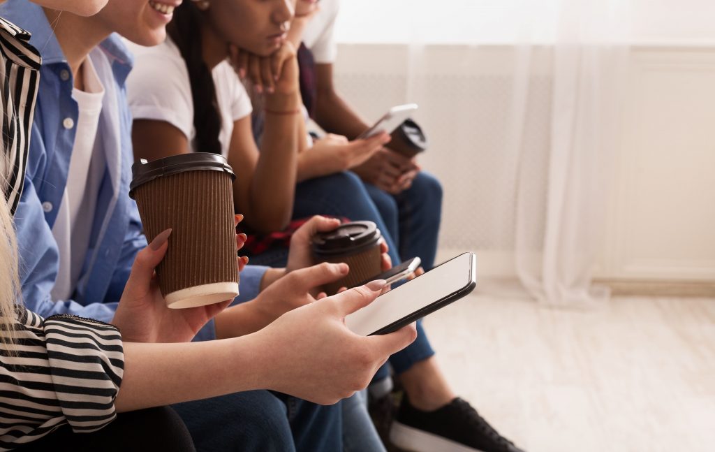 avanco-da-tecnologia-varias-pessoas-mexendo-no-celular-segurando-copo