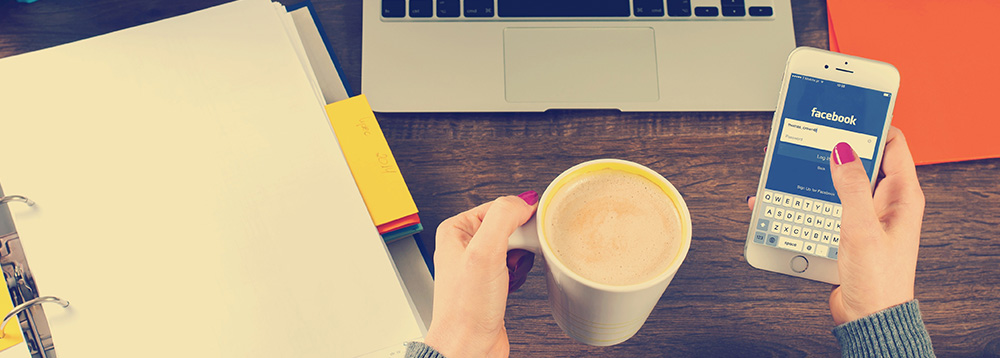 como-conquistar-fieis-na-internet-mulher-acessando-facebook-pelo-smartphone-tomando-cafe