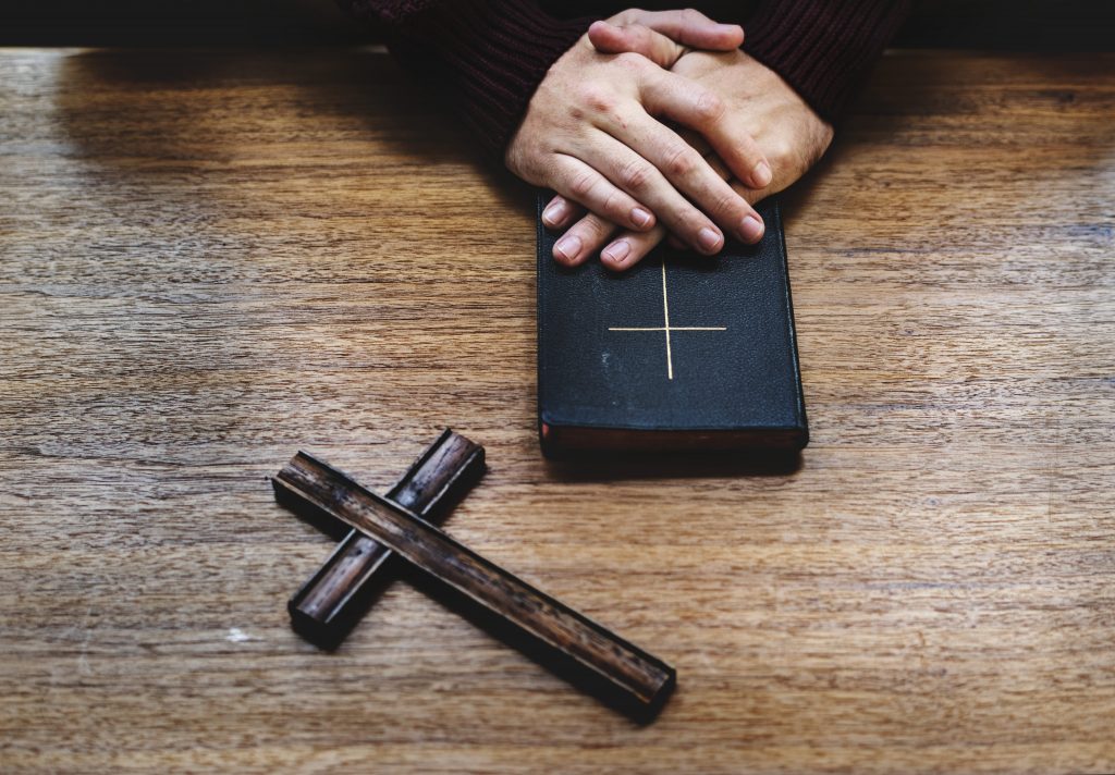 homem-segurando-a-biblia-crucifixo-oracao