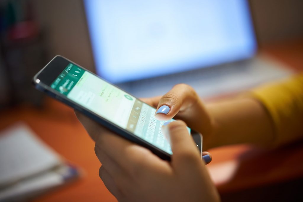 novas-tecnologias-mulher-mexendo-no-celular-whatsapp-respondendo-computador