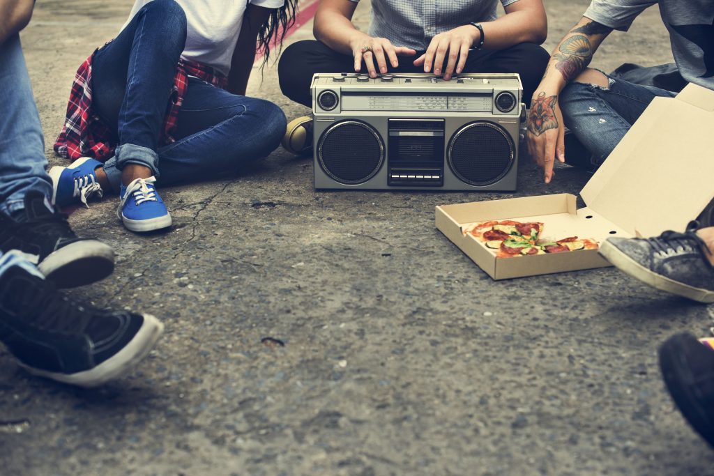 radio-online-jovens-sentados-no-chao-rodeados-por-um-pedaco-de-pizza-e-um-aparelho-de-radio