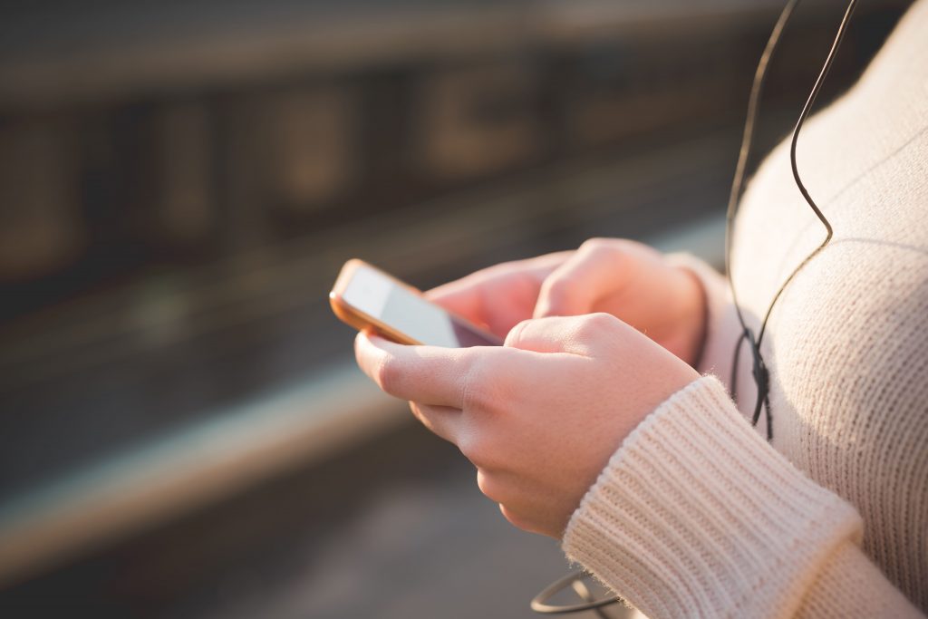 radio-online-mulher-com-fone-mexendo-no-celular