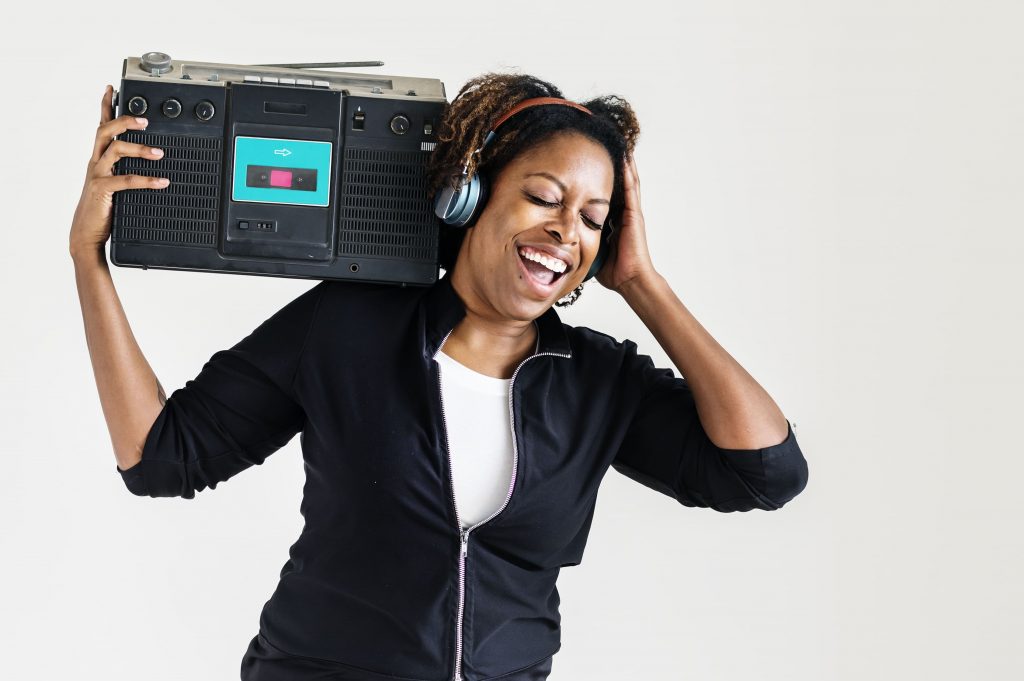 radio-online-mulher-negra-escutando-com-um-aparelho-de-radio-nos-ombros