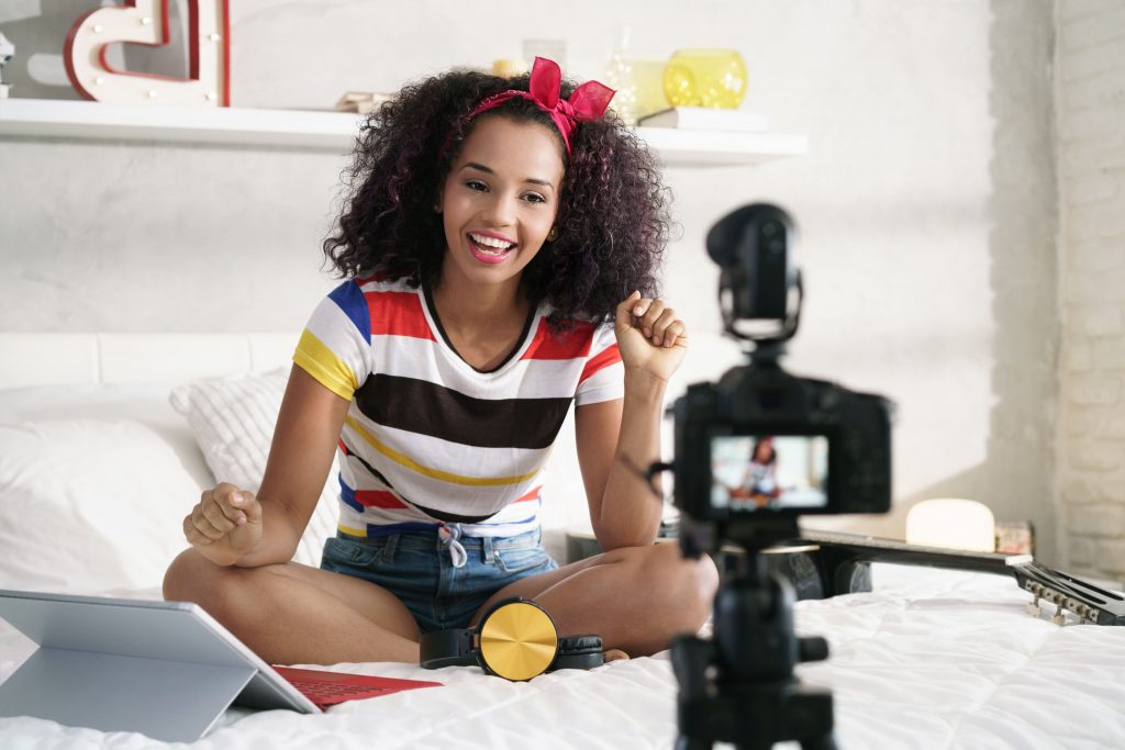 tv-e-internet-mulher-jovem-cabelos-cacheados-gravando-video-no-quarto