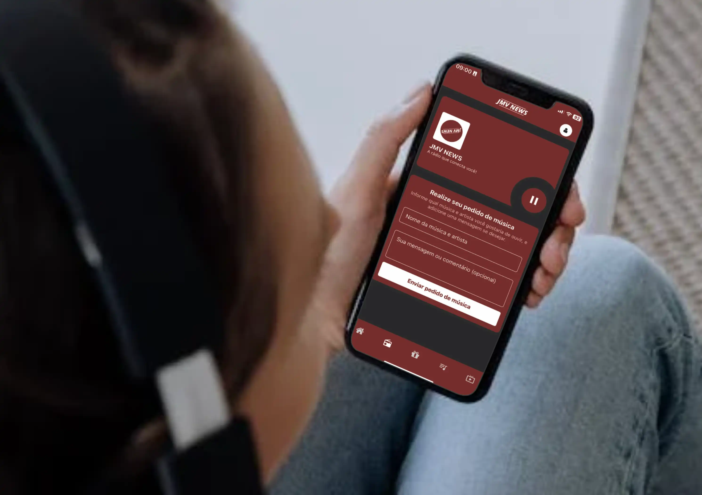 Ouvinte usando fones de ouvido enquanto utiliza o aplicativo JMV News para fazer pedidos de música