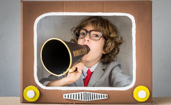 marketing-promocional-crianca-terno-e-gravata-anunciando-na-televisao-com-megafone